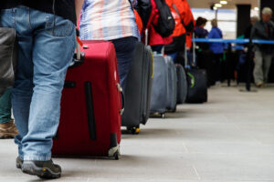 a group of people with luggage in immigration line at airport